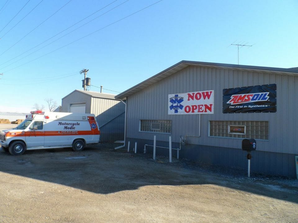 Motorcycle Medic ambulance van beside the shop with a Now Open banner