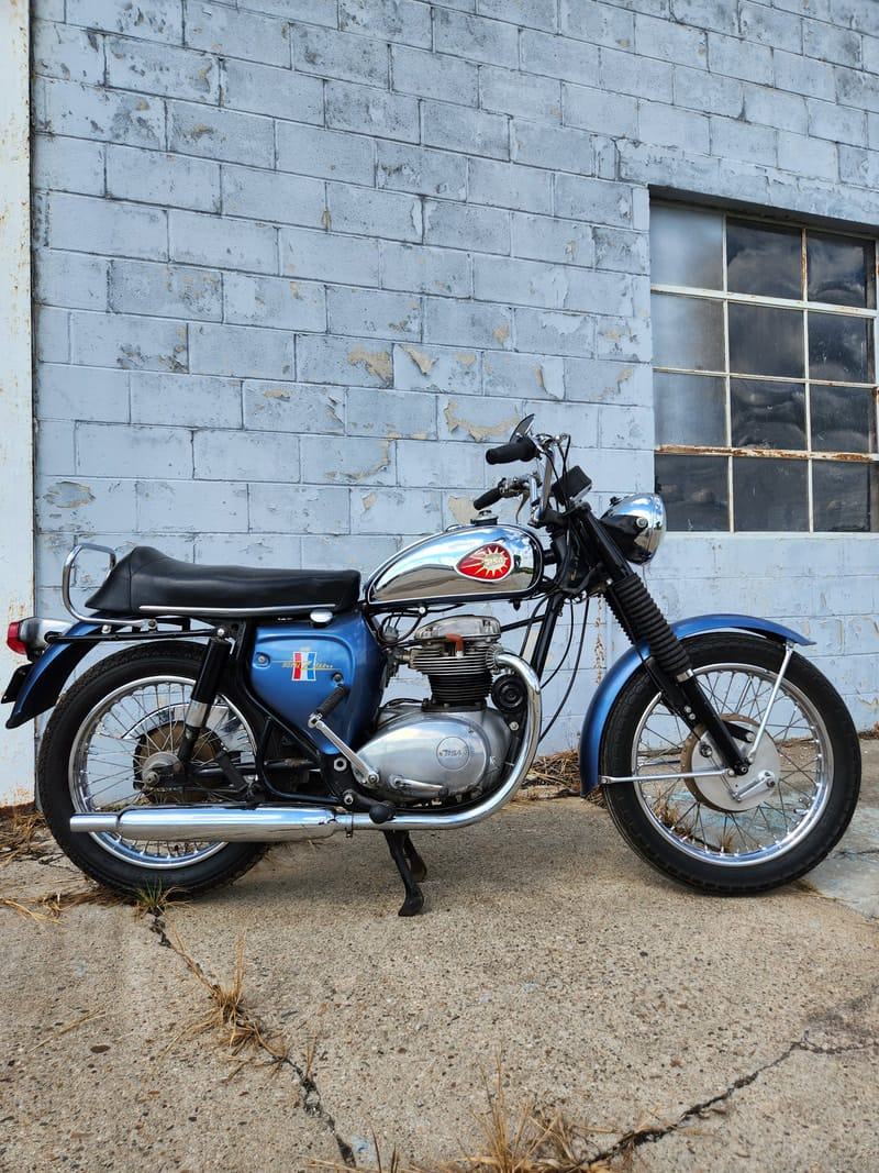 Restored vintage BSA Royal Star motorcycle against the shop wall